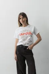 Remera de algodón blanca, con cuello redondo y mangas cortas. Presenta un estampado frontal con la palabra "KAPSUL" en rojo sobre un diseño floral en tono beige.