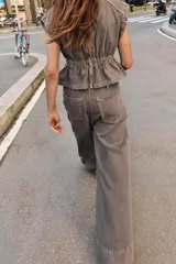 Jeans de tiro medio con corte wide leg y pernera ancha. Presenta pinzas delanteras, bolsillos frontales, bolsillos de plastrón en la espalda y cierre frontal con cremallera, botón interior y ganchos metálicos.