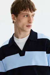 Remera polo de manga corta y corte holgado, confeccionada en punto de mezcla de viscosa. Presenta un diseño de rayas horizontales en color celeste y negro, con cuello acanalado y abertura frontal en V.