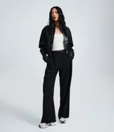 Pantalón de vestir estilo sastre, de corte recto y tiro medio. Presenta pliegues discretos en la parte delantera, perneras amplias y cierre clásico. Incluye un cinturón fino con hebilla metálica.