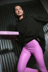 Pantalón largo de ecocuero color lila, con tiro alto, calce ajustado y botamanga irregular.