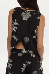 Top negro sin mangas, con escote redondo y estampa artesanal de motivos botánicos y de insectos en color crudo. Diseño cruzado en la espalda.