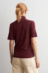 Polera de manga corta con cuello alto, confeccionada en tejido acanalado de color bordó con efecto melange.
