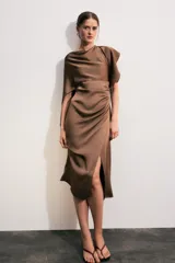 Vestido midi de satén color marrón, con cuello redondo, manga corta con capa fluida y cintura entallada con pliegues. Cuenta con falda recta con abertura en el bajo y cierre lateral con cremallera oculta.