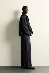 Jeans de corte relajado y pierna recta, confeccionados en denim de algodón rígido. Presentan tiro medio, cierre frontal con cremallera y botón, y diseño clásico de cinco bolsillos.
