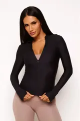 Campera negra de poliamida y elastano con textura tipo panal, cierre frontal completo, cuello alto y mangas largas con orificios para los pulgares.
