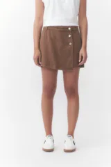Short pollera color marrón chocolate, con diseño cruzado en el frente y detalle de tres botones metálicos en la cintura.