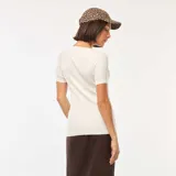 Remera blanca de tejido de punto de canalé, con cuello redondo amplio y mangas cortas.