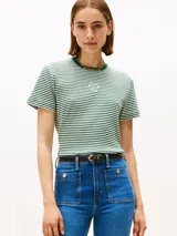 Remera de manga corta con cuello redondo y ribete en color verde oscuro. Presenta un patrón de rayas horizontales alternadas en blanco y verde. Tiene un pequeño logo circular bordado en blanco en el centro del pecho.