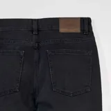 Pantalón de jean negro de corte recto, con bolsillos delanteros y traseros.