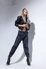 Chaqueta bomber negra de cuero sintético con mangas largas y cierre frontal.