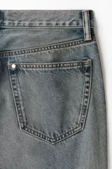 Jean de corte recto en denim de algodón rígido, con diseño de cinco bolsillos y acabado con efecto desgastado.