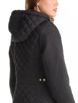 Campera matelassé de largo midi, con diseño combinado de rombos en el cuerpo y costuras horizontales en las mangas. Cuenta con cierre frontal oculto, botones a presión dorados, capucha con interior aterciopelado y ajuste entallado en la cintura.