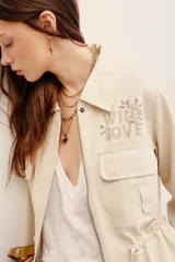 Campera estilo militar color beige, con cierre frontal y bolsillos aplicados en el pecho.
