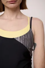 Malla entera de lycra con diseño color block en negro, amarillo y rayas verticales blancas y negras.