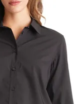 Camisa de corte clásico con cuello camisero, cierre frontal de botones y mangas largas con puños abotonados.