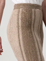 Falda de crochet color tostado con diseño de rayas verticales texturizadas, corte recto y forro interior.