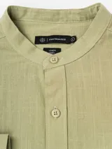 Camisa de manga larga Cuatroases color azul, confeccionada en algodón con textura tipo lino, cuello mao y cierre frontal de botones.