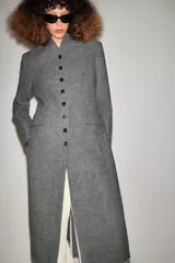 Abrigo largo gris melange de lana de la colección ZW de Zara, con cuello subido, cierre frontal abotonado y bolsillos con solapa en el delantero.