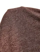 Vestido corto de punto color marrón, con escote asimétrico tipo bote y mangas largas. Presenta un diseño ajustado al cuerpo.