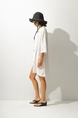 Vestido corto de cuero negro, sin mangas y con cuello redondo. Presenta un corte ajustado al cuerpo.