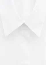 Camisa de algodón de diseño recto, cuello camisero, manga tres cuartos y cierre delantero de botones ocultos con tapeta.