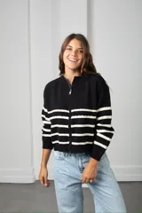 Saco de punto con cierre frontal, diseño a rayas horizontales negras sobre base color crema, de manga larga y calce holgado.