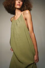 Vestido midi de corte recto y fluido, con cuello redondo y tirantes finos que se ajustan en la espalda mediante una lazada.