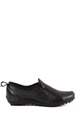 Zapato de cuero artesanal negro con diseño calado, cierre lateral en diagonal y suela plana texturizada.