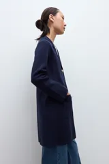 Sacón azul marino de corte largo, con cuello solapa, cierre frontal de dos botones dorados y bolsillos de parche.