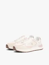 Zapatillas de corte bajo confeccionadas en ante con mezcla de texturas en tonos beige, crema y rosado. Presentan cierre de cordones, suela de EVA blanca con base de goma marrón, insignia con monograma TH en el lateral y logo de Tommy Hilfiger en bajo relieve en el talón.