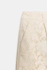 Shorts de tiro alto confeccionados en encaje con diseño floral. Presentan bolsillos delanteros y cierre frontal con cremallera y gancho metálico.