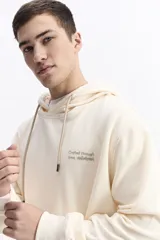 Canguro con capucha y cordones ajustables, de corte holgado y bolsillo frontal tipo canguro. Presenta un pequeño logo estampado en el pecho.