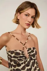 Vestido largo con estampado de manchas marrones sobre fondo beige, escote halter con tirantes finos y detalle de cuentas, calce suelto y largo midi.