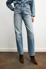 Jeans celeste de tiro alto, corte recto y largo, con cinco bolsillos y cierre frontal con cremallera y botón.