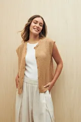 Chaleco tejido calado color blanco, sin mangas, con botones al frente y diseño abierto.