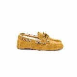 Mocasines de gamuza color mostaza, con detalles de anillos metálicos plateados en los laterales y cordones decorativos en el empeine.