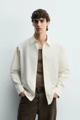 Camisa regular fit de color celeste, confeccionada en tejido con mezcla de algodón y seda, con cuello solapa, manga larga con puño abotonado y cierre frontal de botonadura.