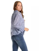 Camisa de manga larga confeccionada en algodón con delicados bordados florales en toda la prenda. Presenta cuello clásico con solapa, cierre frontal con botones y un corte holgado.