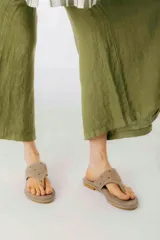 Sandalias de cuero color beige con apliques metálicos redondos.