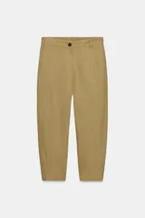 Pantalón capri color verde oliva, de tiro medio, confeccionado en mezcla de lino. Presenta bolsillos laterales y traseros, y cierre frontal con cremallera y botón.