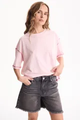 Remera oversize de manga corta color rosado, con cuello redondo y costuras externas en contraste de color bordó.