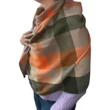 Bufanda rectangular de tejido afelpado con diseño de cuadros en tonos rosado, gris y beige. Presenta terminaciones con flecos en los extremos.