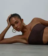 Vestido midi de Blue Steel color marrón, con textura en relieve, escote strapless, diseño ajustado al cuerpo con recorte cut out lateral en la cintura y tajo en la falda.