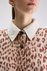 Sobrecamisa de calce relajado y estampado animal print con diseño de leopardo. Cuenta con cuello camisero en color blanco de textura acanalada, cierre frontal de botones a presión, mangas largas y bolsillos frontales aplicados.