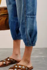 Jean de tiro medio-alto y calce holgado, con piernas anchas que se estrechan hacia el tobillo y largo midi. Confeccionado en denim rígido con lavado bleach y cierre frontal con botones.