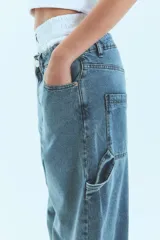 Jean de corte baggy y tiro bajo, en color azul lavado. Presenta un diseño holgado con presillas anchas y cierre frontal con botón metálico.