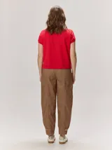 Pantalón de lino color blanco crudo, de corte barrel, con bolsillos laterales y costuras pespunteadas a contratono.