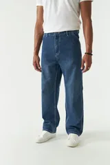 Pantalón tipo jean de corte carpenter, con diseño relajado, recto y amplio. Presenta costuras reforzadas, pasa cinto y bolsillos laterales.