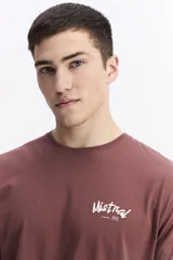 Remera de manga larga color bordó con escote redondo y estampado en la espalda que dice "Mistral Studio limited edition" en blanco.